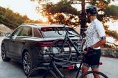 Male cyclist loading his bicycle on a rack of his crossover car