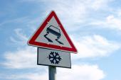 Traffic sign warns about slippery road ahead zimní cesta